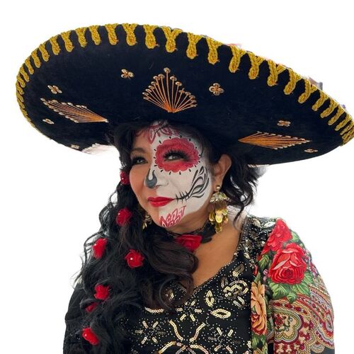 Portrait of Executive Director Mary Ann Castilleja Labowski wearing a traditional sombrero and Dia de los Muertos skull face paint
